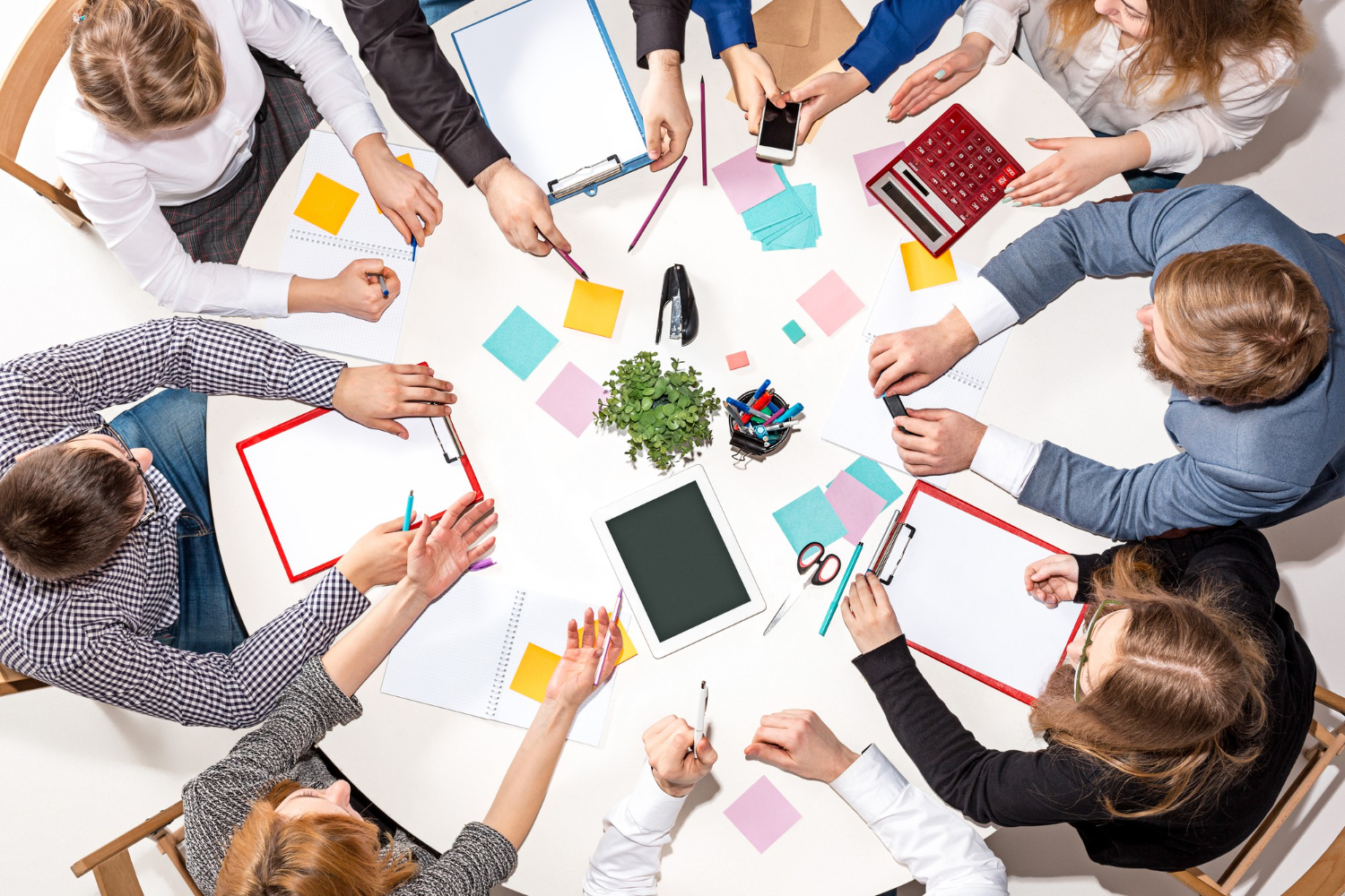 team-sitting-desk-checking-reports-talking-top-view